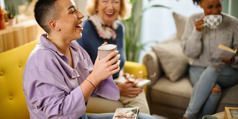 Small group of people with a mixed age range talking during a book club meeting.